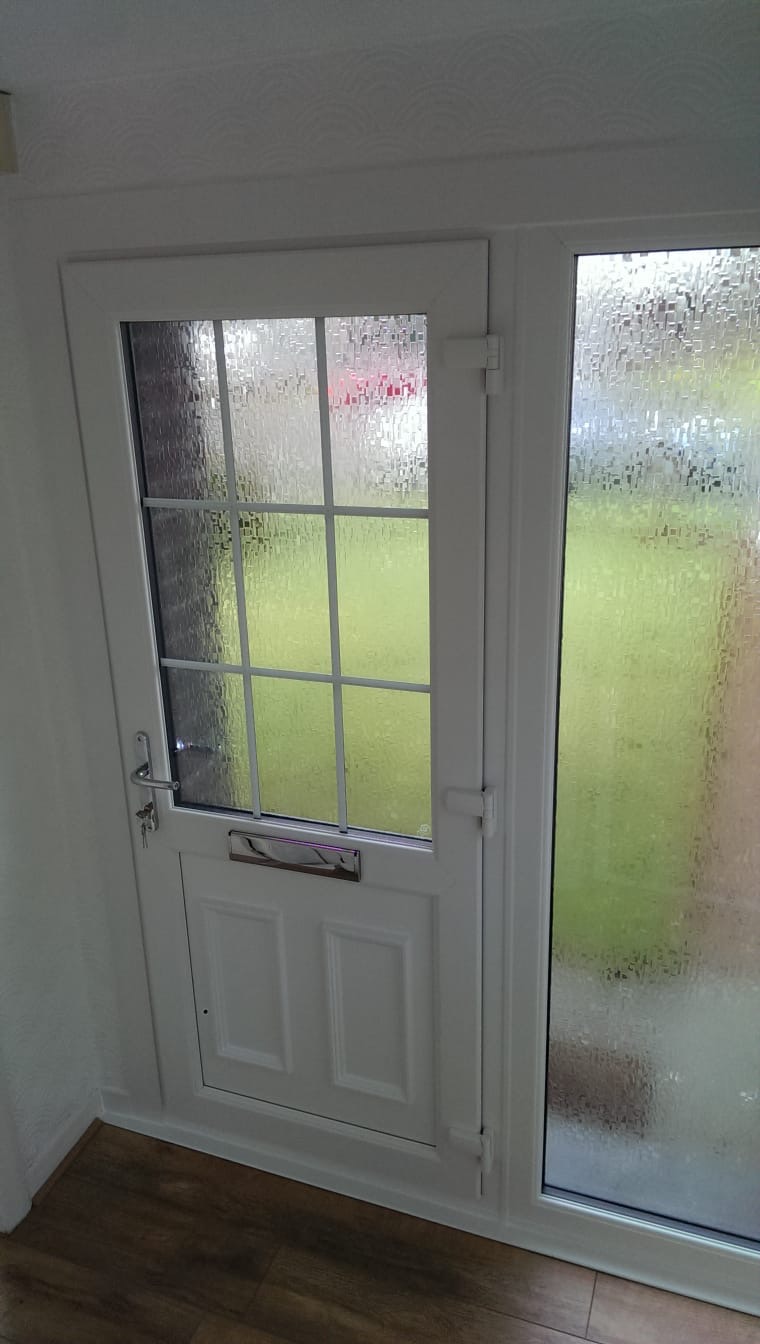 White uPVC back door with six-pane glazed upper half and frosted side panel